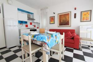 利多波波萨Eco del Mare Apartments的厨房配有桌子和红色沙发