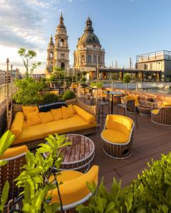布达佩斯布达佩斯图书馆酒店集团咏叹调酒店的一个带黄色家具和钟楼屋顶庭院