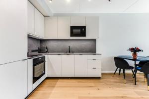塔林15 korruse premium katusekorter的厨房配有白色橱柜和桌椅