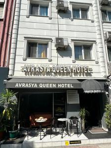 伊斯坦布尔AVRASYAQUEEN HOTEL的大楼前设有桌椅的餐厅