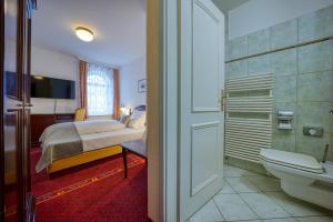 维斯马Hotel Seeblick Wismar的一间卧室配有一张床,浴室设有卫生间