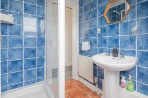 HistonModern Stylish Cambridge Pad (Free Parking)的蓝色瓷砖浴室设有水槽和浴缸