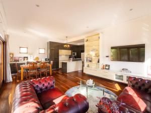 布里斯班6KM to CBD Convenient 5BR Queenslander Coorparoo的一间带真皮沙发的客厅和一间厨房