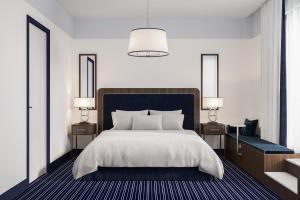 滕斯贝格Hotel Klubben的一间卧室配有一张大床、两张桌子和两盏灯。