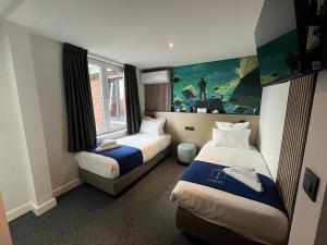 穆斯克龙Elberg Hotel & Apartments的酒店客房设有两张床和窗户。