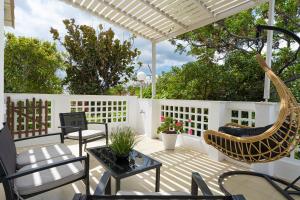 阿达玛斯Semiramis Guesthouse的白色围栏上带椅子和吊床的庭院