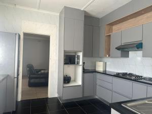 哈拉雷Impeccable 3-Bed House in Harare的厨房配有白色橱柜和黑色地板