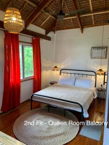 卢纳将军城Wayans Siargao的一间卧室配有红色窗帘和地毯的床