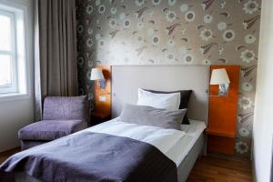 加勒穆恩Clarion Hotel Oslo Airport的配有一张床和一把椅子的酒店客房