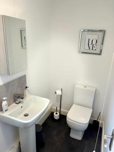 DenbyTHE GARDEN SUITE的浴室配有白色卫生间和盥洗盆。