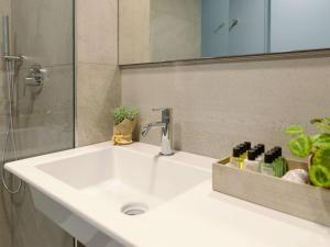 阿格拉泰布里亚恩扎Mercure Milano Agrate Brianza的浴室设有白色水槽和镜子