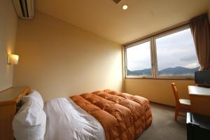 Yokkaichiホテルパブリック21的一间卧室设有一张床和一个大窗户