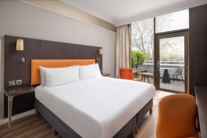 伦敦伦敦海德公园希尔顿逸林酒店的酒店客房设有一张床和一个阳台。