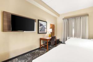哥伦比亚Comfort Suites Columbia at Harbison的酒店客房配有一张床和一张书桌及一台电视