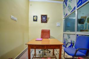 德奥加尔SPOT ON Shashi Prabha Palace的一间设有桌子、两把椅子和时钟的房间