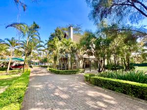 阿鲁沙Wenzi Luxury Home的棕榈树房屋和砖车道