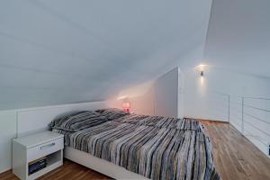 波斯蒂拉Apartment Vila Inga的一间白色卧室,配有床和床头柜