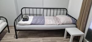 圣珀尔滕APARTMENTS RATZERSDORFER SEEN in 3100 SANKT PÖLTEN的一张带枕头和桌子的黑色床