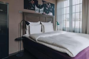 松德比贝里Story Hotel Signalfabriken, part of JdV by Hyatt的卧室配有一张带白色床单和枕头的大床。