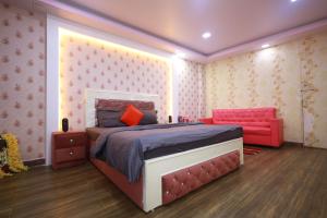 巴特那Raj Resort的一间卧室配有一张床和一张红色的沙发