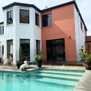 黄金海岸Relaxing Burleigh Heads Home with Swimming Pool的房屋前有游泳池的房子