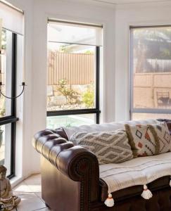 黄金海岸Relaxing Burleigh Heads Home with Swimming Pool的带沙发和2扇窗户的客厅
