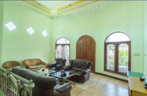 马塔兰Senaz Guesthouse的客厅配有沙发和桌子