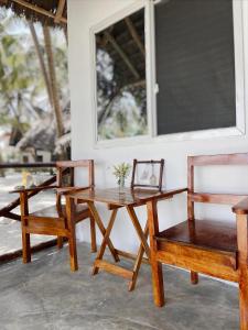 布韦朱Zanzibar Gem Beach Bungalows的一张桌子和两张椅子以及一张桌子和一张桌子