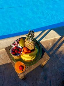 斯卡拉拉乔伊Olive Dream Thassos Luxury Villas的池边桌子上的一盘水果