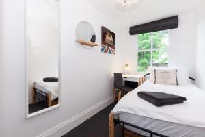 牛津Trendy Terraced House in Central Oxford的一间卧室配有两张床和镜子