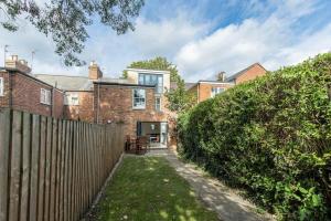 牛津Trendy Terraced House in Central Oxford的砖屋,有栅栏和院子