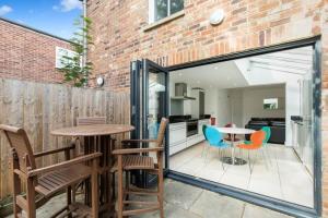 牛津Trendy Terraced House in Central Oxford的一个带桌椅的庭院和一间厨房