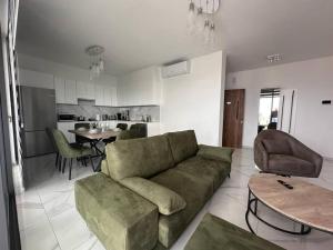 拉纳卡Cozy 3 Bedroom Apartment 300M from the SEA的一间带绿色沙发的客厅和一间厨房