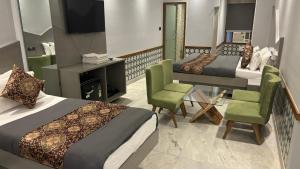 新德里Hotel Cottage Yes Please - New Delhi的酒店客房带两张床、电视和椅子。