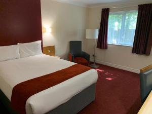 南安普敦南安普敦若汉姆戴斯酒店的酒店客房带一张大床和一把椅子