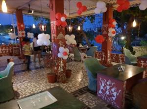乌代浦Salera Nature Nest Hotel的一间带桌椅和气球的餐厅
