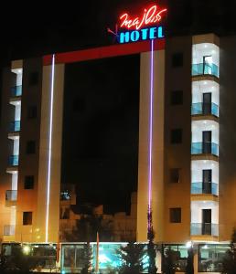 拉巴特Majliss Hotel Downtown的夜间带有 ⁇ 虹酒店标志的酒店大楼
