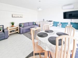 波尔蒂芒Apartment Concorde Sky Vista Mar的客厅配有桌子和紫色沙发