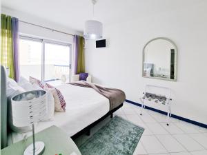 波尔蒂芒Apartment Concorde Sky Vista Mar的一间卧室配有一张大床和镜子