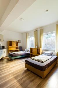 开姆尼茨Apartmenthaus in Chemnitz für Monteure的大客房铺有木地板,配有两张床。