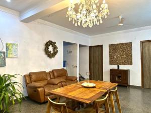 古尔冈3 BHK entire villa near Medanta hospital的客厅配有桌子和沙发