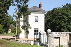 圣艾尼昂La maison de Léonard, Aux grilles du Château de Saint-Aignan, à 2km de Beauval的一座带石墙的白色旧房子