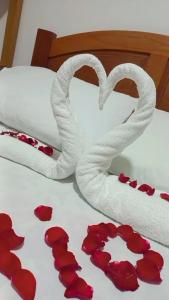 蒙特韦尔迪Chalés lima的一张带两个红心和红色玫瑰花垫的床