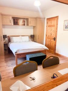 KilcarKilcar Lodge的卧室配有一张床和一张桌子及椅子