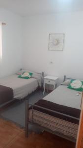 德尔锡伦西奥海岸costa del silencio的一间卧室设有两张床和白色的墙壁