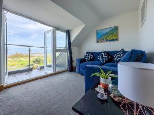 卡斯特Waves Guest Suites的客厅设有蓝色的沙发和大窗户