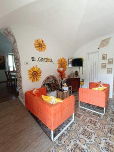 菲纳莱利古雷B&B Il Girasole的客厅配有2张橙色沙发和壁炉