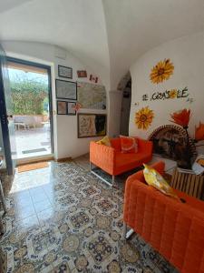 菲纳莱利古雷B&B Il Girasole的客厅配有橙色沙发和壁炉