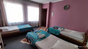 博孔巴耶沃Guest House Emily的配有粉红色墙壁的客房内的两张床