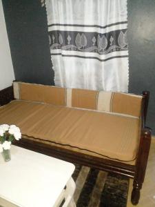 MapenyaIkulu house的靠窗的客厅里一张棕色的沙发